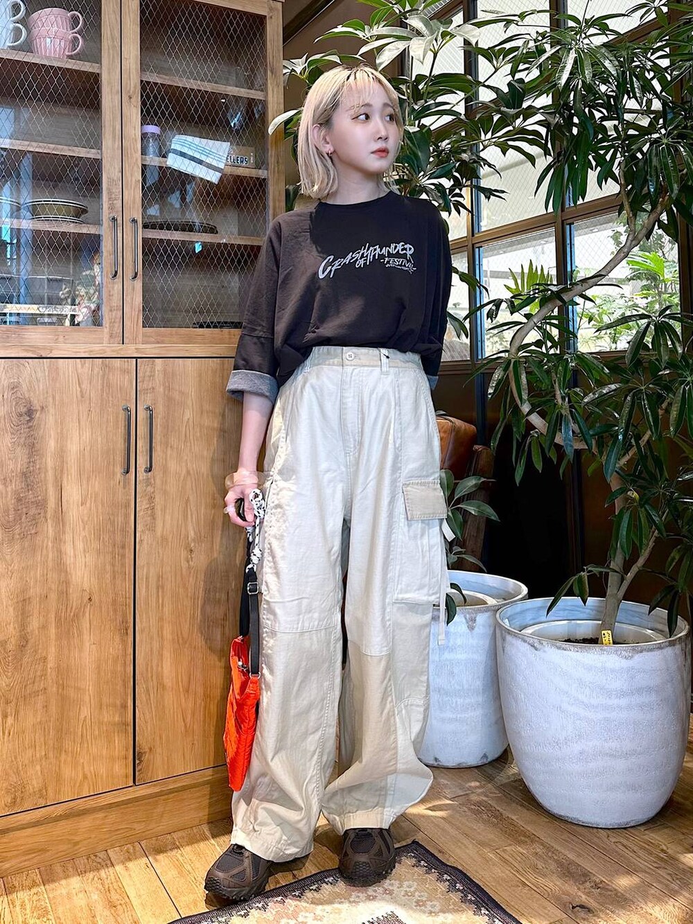 ブラック系のTシャツ/カットソー、レッド系のショルダーバッグ、ベージュ系のカーゴパンツを着用したレディースの夏コーディネートの2枚目の写真