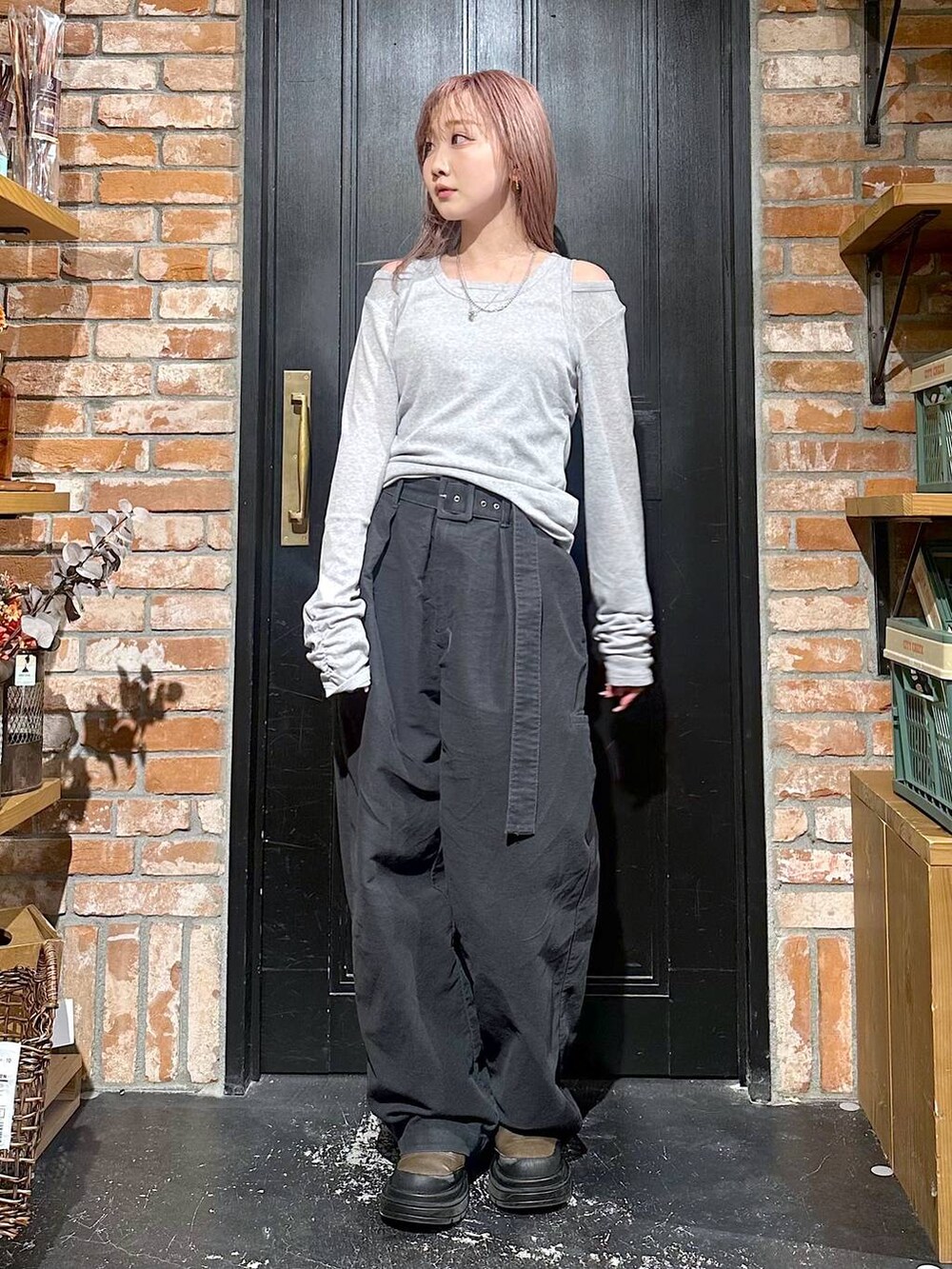 グレー系のその他パンツ、ブラウン系のブーツ、イエロー系のピアス(両耳用)を着用したレディースの冬コーディネートの5枚目の写真