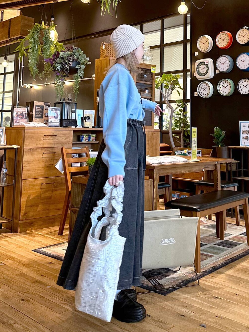 グレー系のトートバッグ、ブラック系のローファー、グレー系のスカートを着用したレディースの冬コーディネートの3枚目の写真