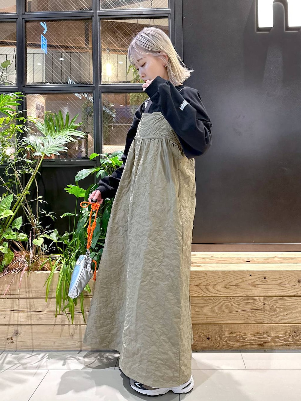 ブラウン系のスニーカー、グレー系のショルダーバッグ、ベージュ系のワンピースを着用したレディースの秋コーディネートの2枚目の写真