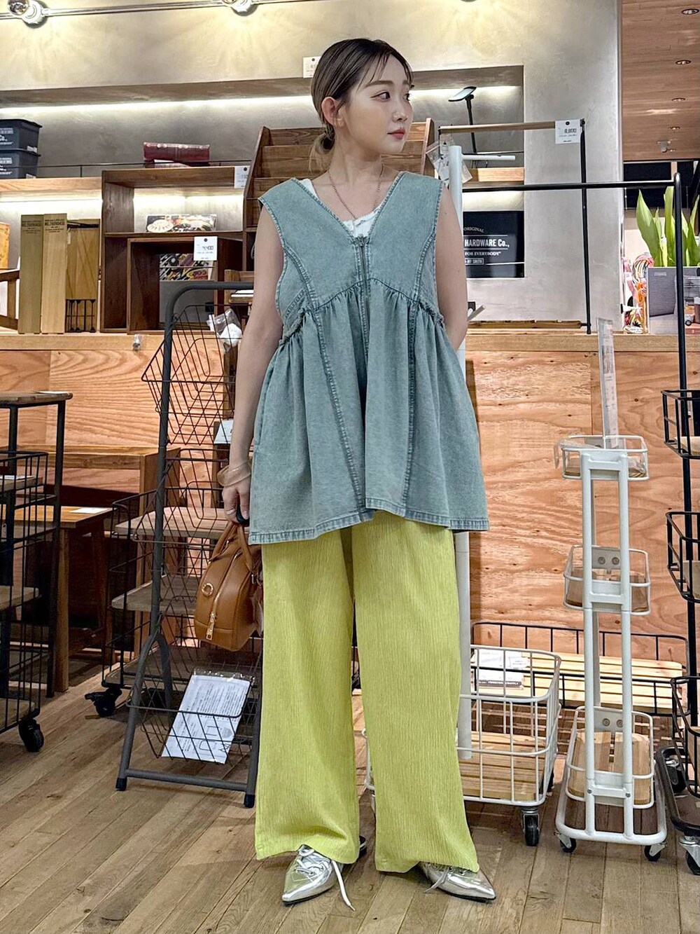 ブルー系のベスト、ホワイト系のタンクトップ、イエロー系のボストンバッグを着用したレディースの夏コーディネートの4枚目の写真