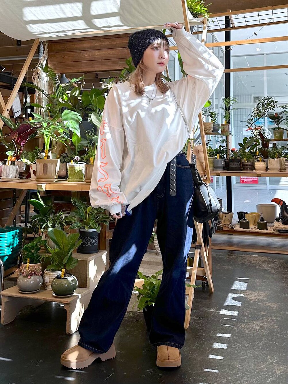 イエロー系のその他シューズ、ブルー系のデニムパンツ、ブラック系のショルダーバッグを着用したレディースの秋コーディネートの5枚目の写真