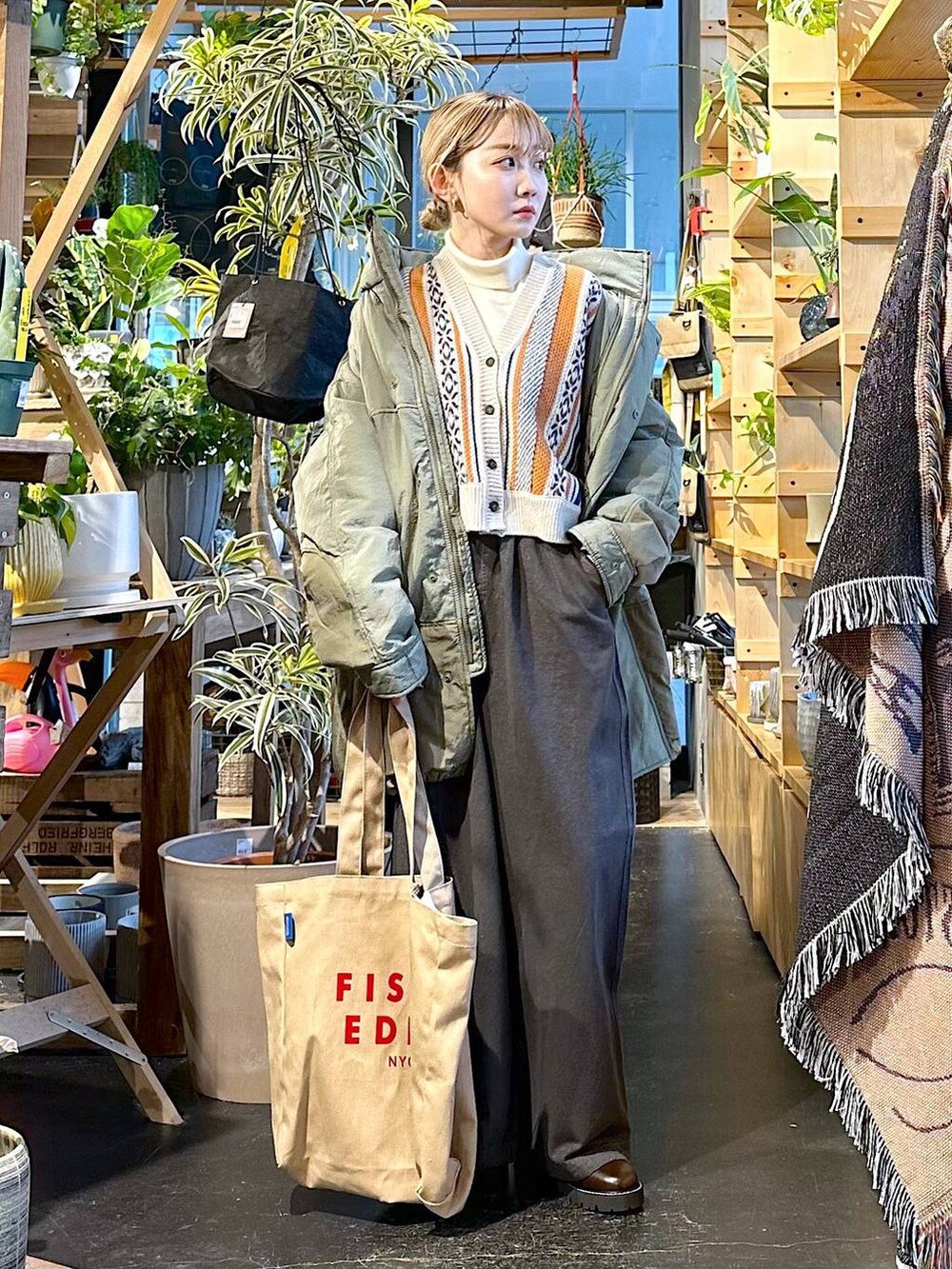 グレー系のその他パンツ、グリーン系のブルゾン、ベージュ系のニット/セーターを着用したレディースの冬コーディネートの5枚目の写真