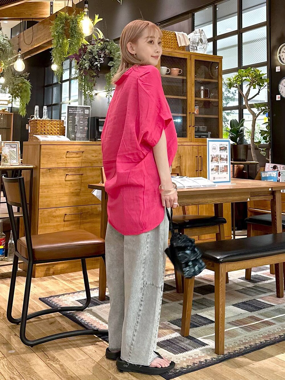 ブラック系のショルダーバッグ、グレー系のデニムパンツ、ブラック系のサンダルを着用したレディースの春コーディネートの3枚目の写真