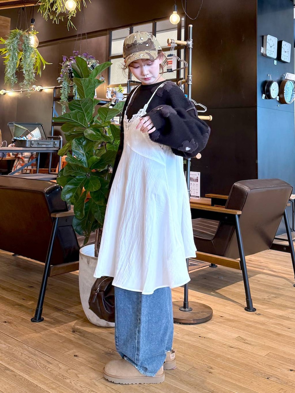 イエロー系のその他シューズ、ブルー系のデニムパンツ、ブラック系のニット/セーターを着用したレディースの冬コーディネートの2枚目の写真