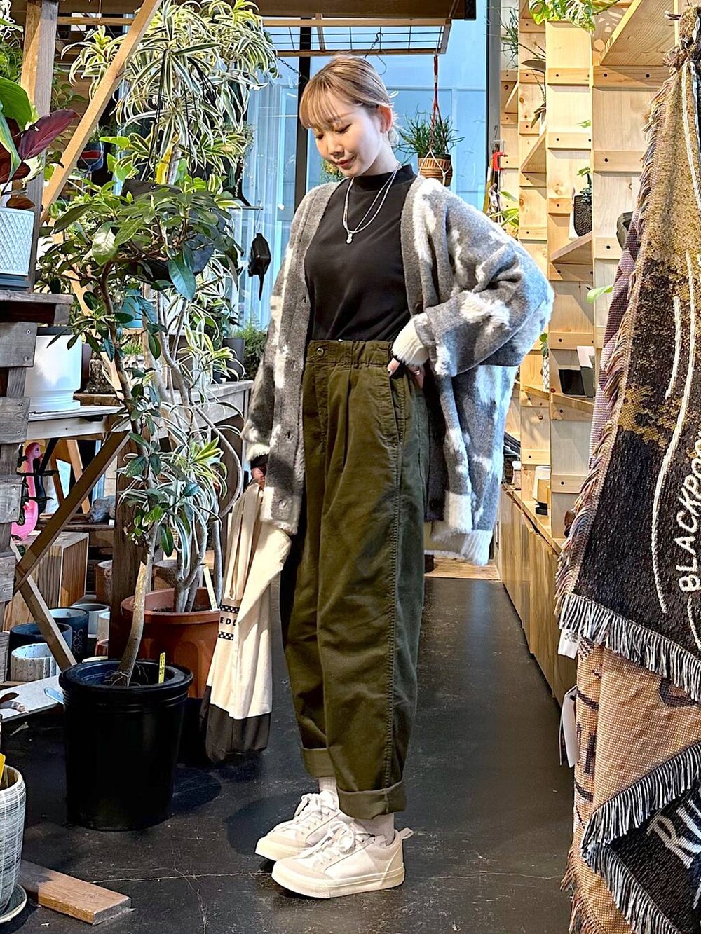 ホワイト系のスニーカー、ブラック系のトートバッグ、ブラック系のTシャツ/カットソーを着用したレディースの冬コーディネートの5枚目の写真