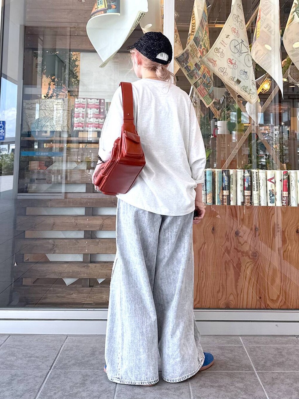 ベージュ系のTシャツ/カットソー、グレー系のデニムパンツ、ブラウン系のショルダーバッグを着用したレディースの夏コーディネートの3枚目の写真