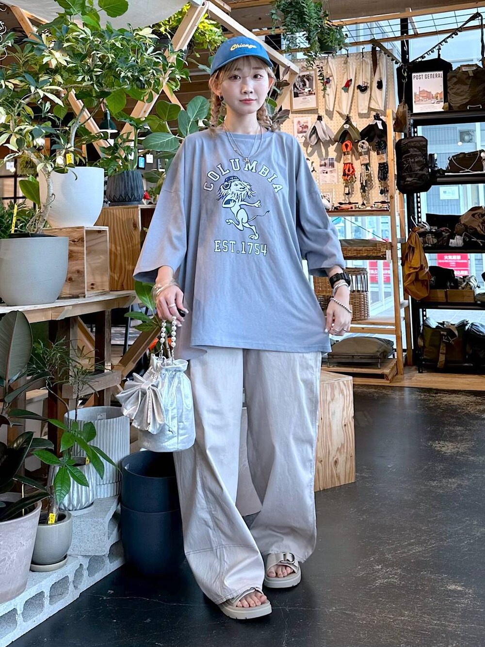 ベージュ系のその他パンツ、グレー系のショルダーバッグ、ブルー系のキャップを着用したレディースの夏コーディネートの2枚目の写真