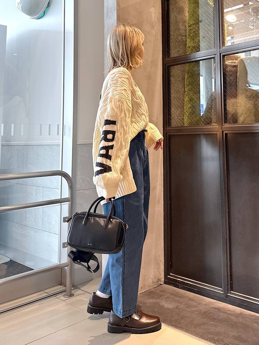 ブルー系のその他パンツ、ブラウン系のその他シューズ、ブラック系のショルダーバッグを着用したレディースの秋コーディネートの3枚目の写真