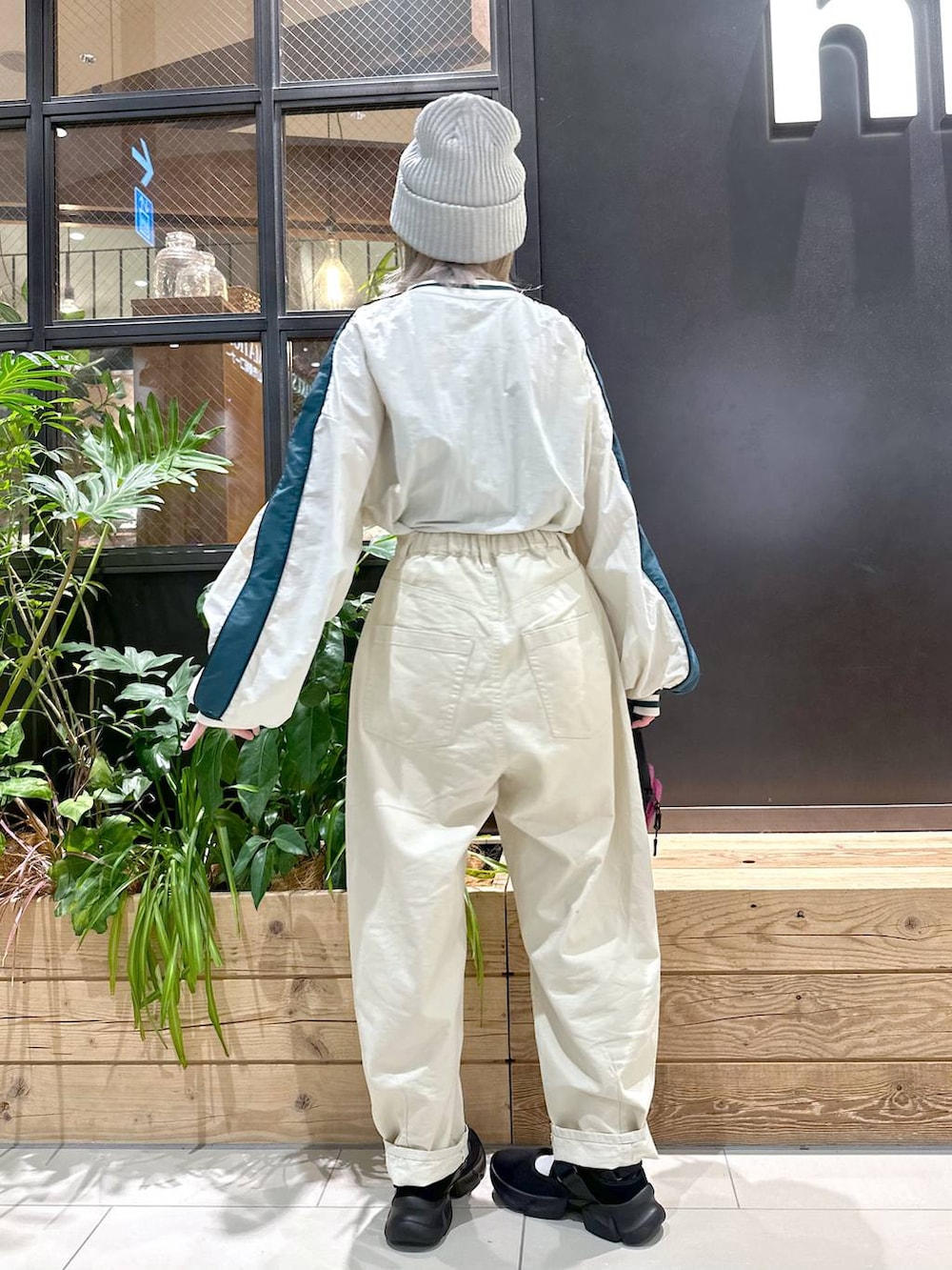 パープル系のショルダーバッグ、ベージュ系のその他パンツ、ブラック系のスニーカーを着用したレディースの秋コーディネートの2枚目の写真