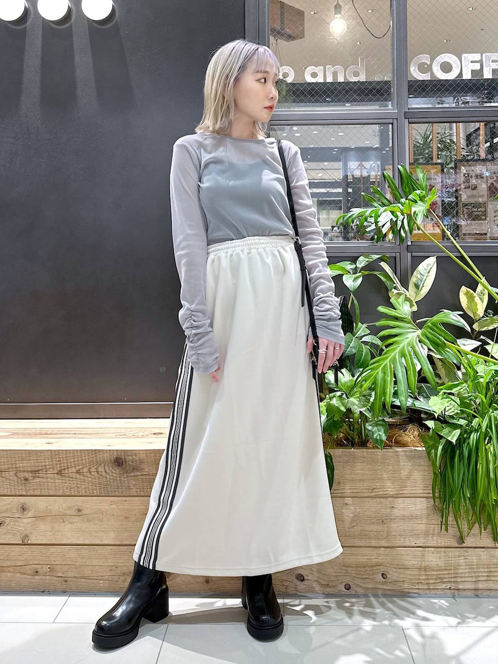 ブラック系のブーツ、グレー系のTシャツ/カットソー、ベージュ系のスカートを着用したレディースの秋コーディネートの4枚目の写真