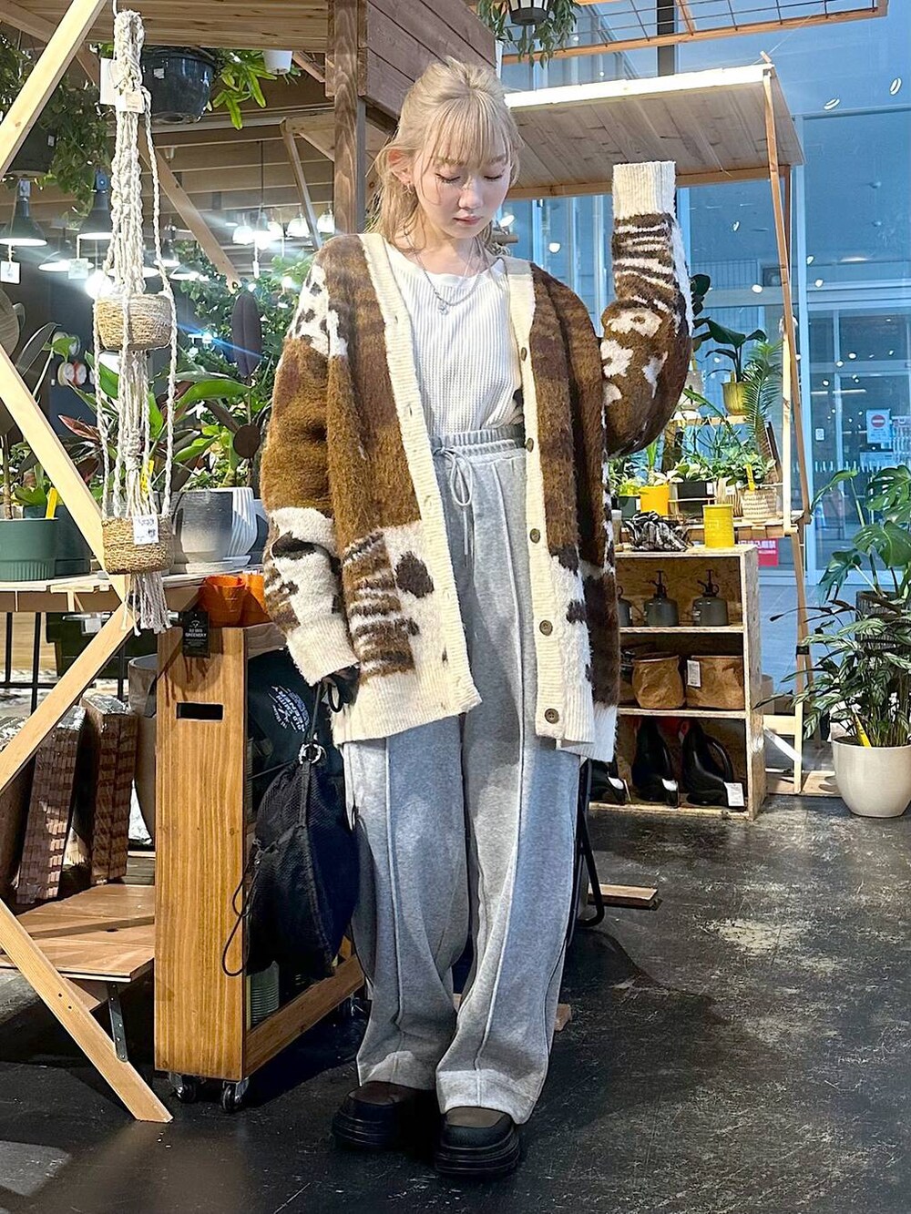 グレー系のその他パンツ、ブラック系のショルダーバッグ、ブラウン系のブーツを着用したレディースの冬コーディネートの3枚目の写真