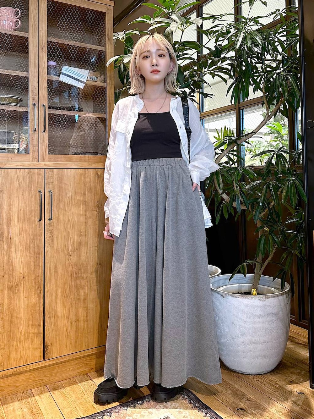 ホワイト系のシャツ/ブラウス、グレー系のショルダーバッグ、ブラック系のモカシン/デッキシューズを着用したレディースの夏コーディネートの2枚目の写真