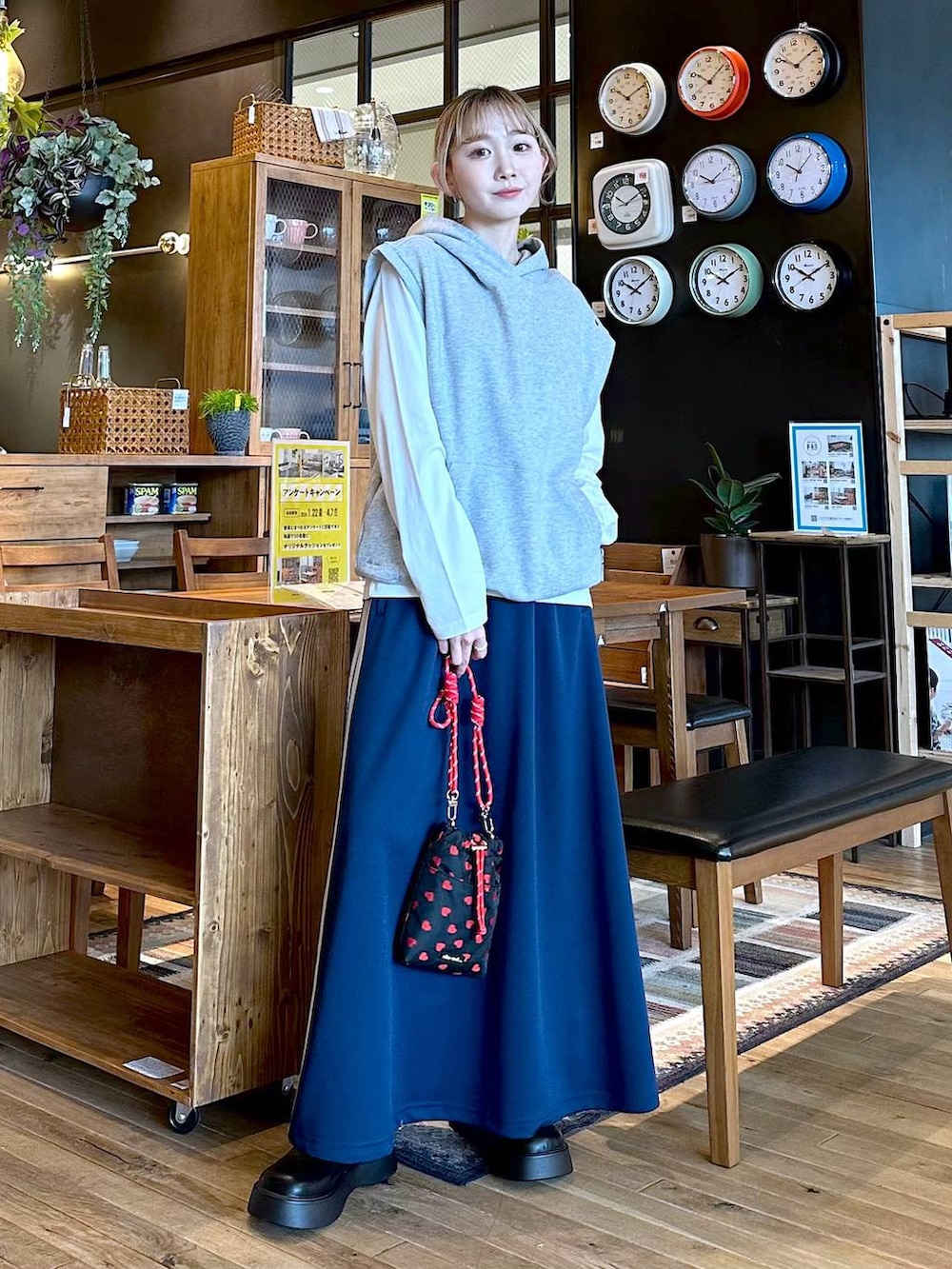 ブラック系のショルダーバッグ、ホワイト系のTシャツ/カットソー、ブルー系のスカートを着用したレディースの冬コーディネートの2枚目の写真