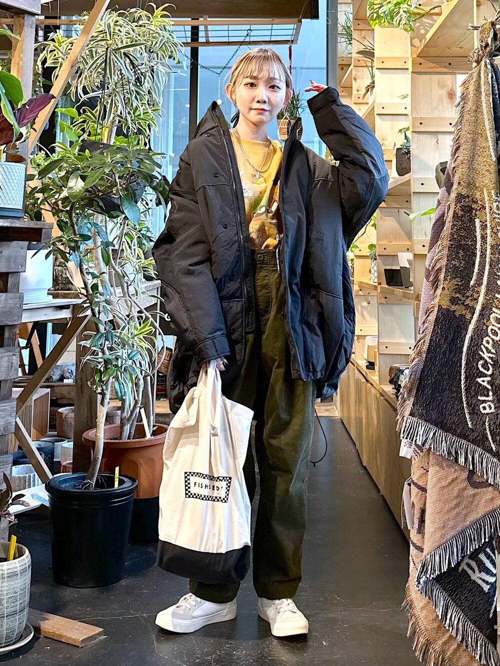 ホワイト系のスニーカー、ブラック系のトートバッグ、その他のブルゾンを着用したレディースの冬コーディネートの3枚目の写真