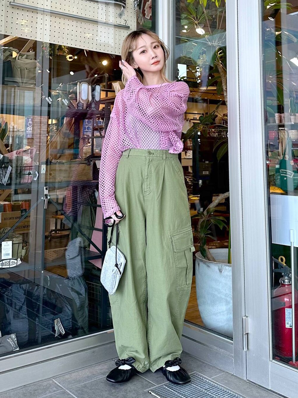 グリーン系のカーゴパンツ、ピンク系のTシャツ/カットソー、グレー系のタンクトップを着用したレディースの春コーディネートの5枚目の写真