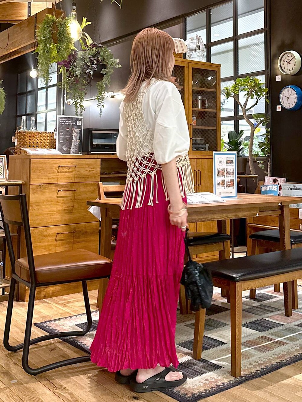 ブラック系のショルダーバッグ、ピンク系のスカート、ホワイト系のTシャツ/カットソーを着用したレディースの春コーディネートの3枚目の写真