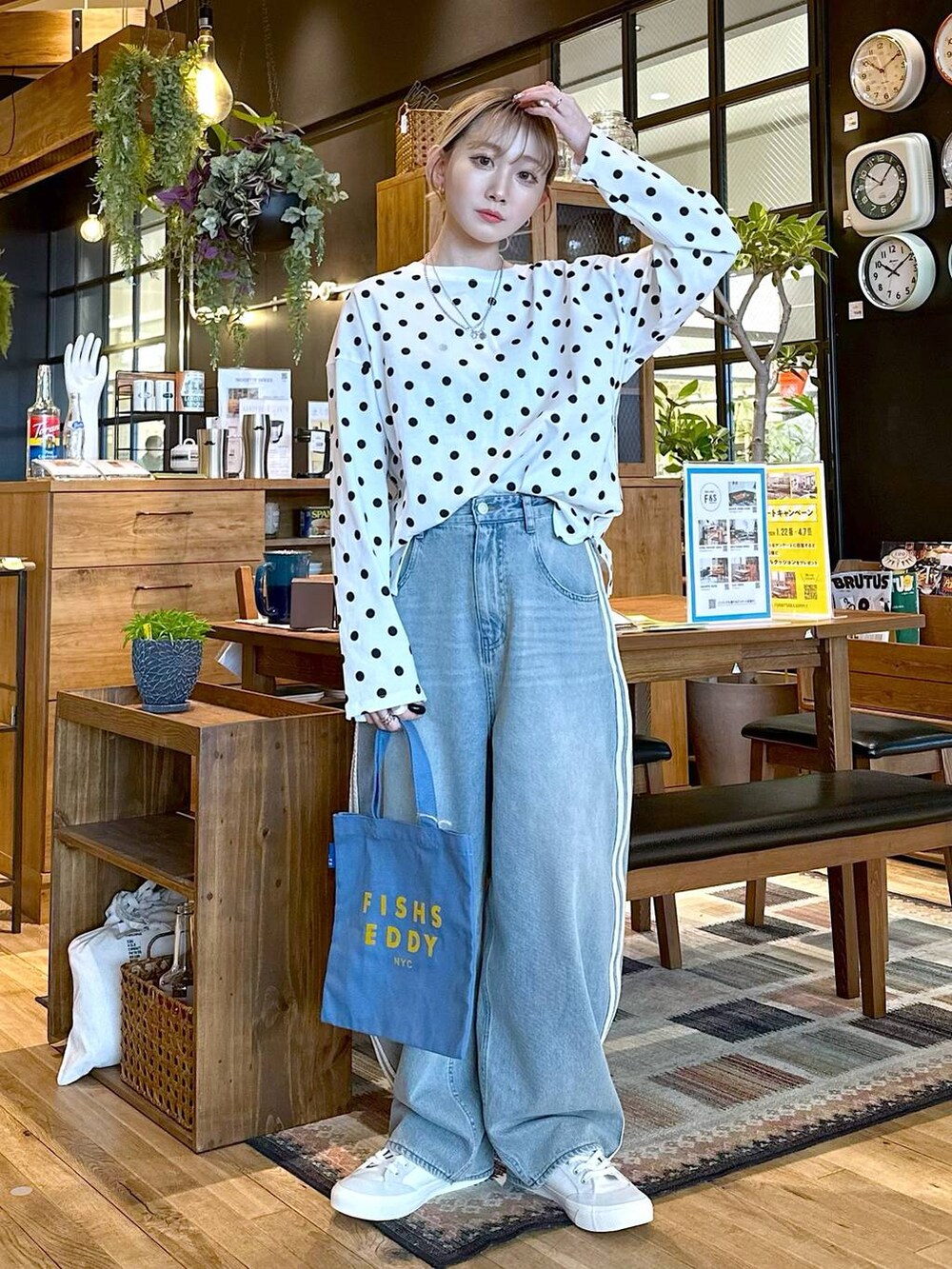 ホワイト系のスニーカー、ブルー系のトートバッグ、ホワイト系のTシャツ/カットソーを着用したレディースの冬コーディネートの4枚目の写真