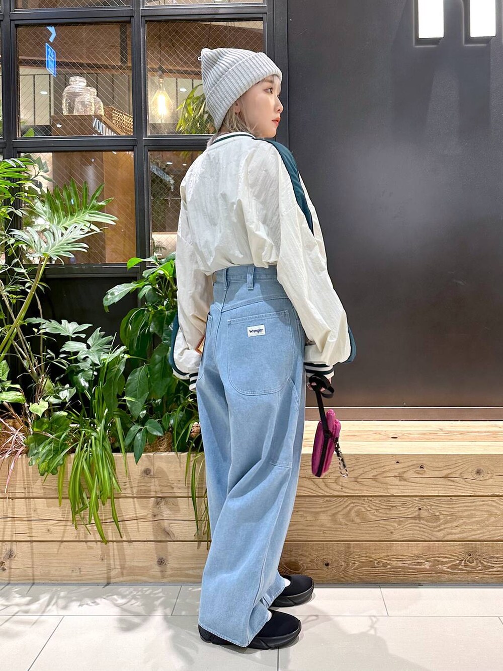 パープル系のショルダーバッグ、ブルー系のその他パンツ、ブラック系のスニーカーを着用したレディースの秋コーディネートの4枚目の写真