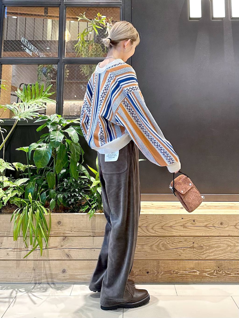 ブラウン系のその他パンツ、オレンジ系のカーディガン/ボレロ、ブラウン系のその他シューズを着用したレディースの冬コーディネートの2枚目の写真