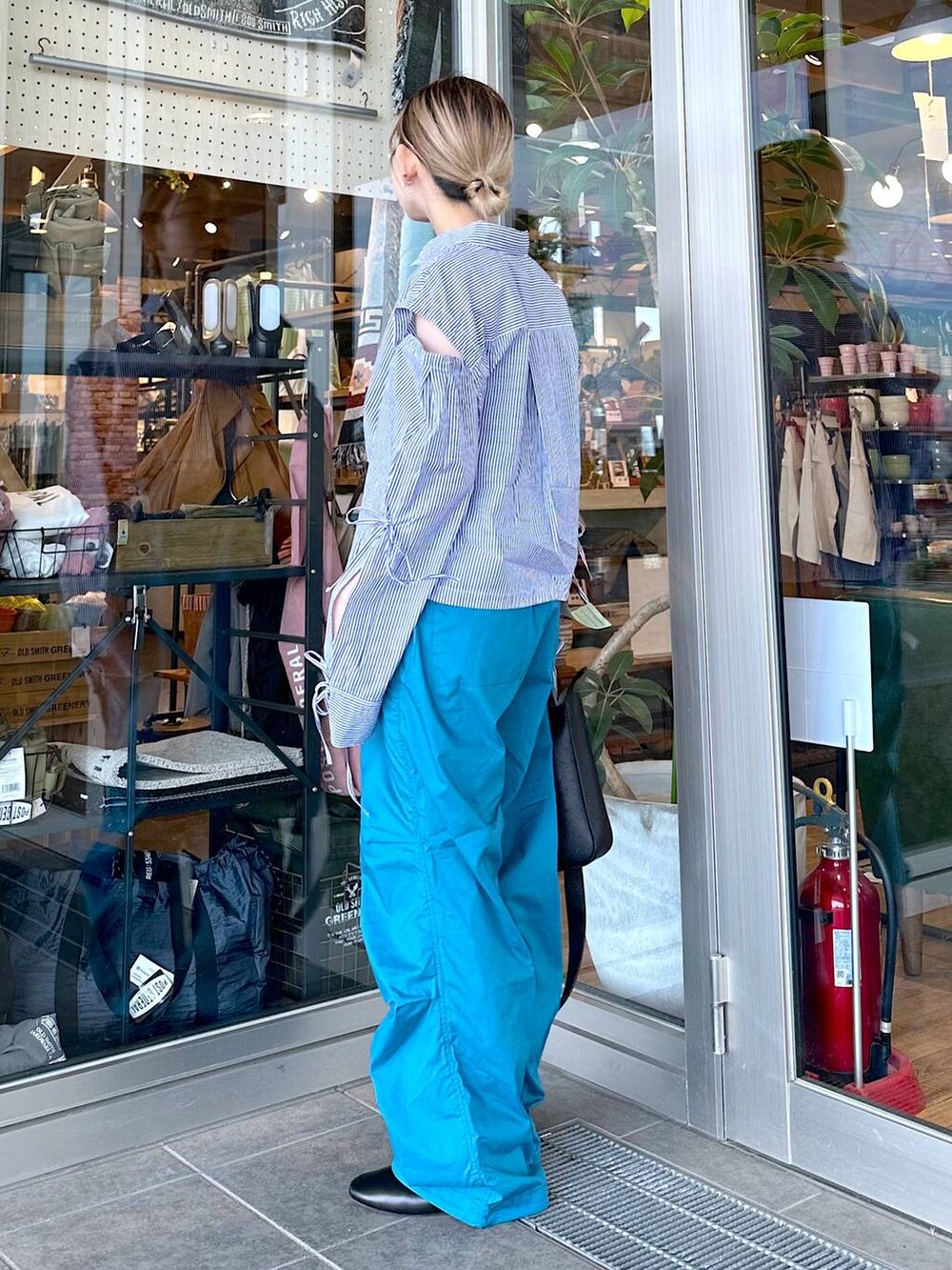 ブラック系のトートバッグ、その他のパンプス、ブルー系のシャツ/ブラウスを着用したレディースの春コーディネートの3枚目の写真