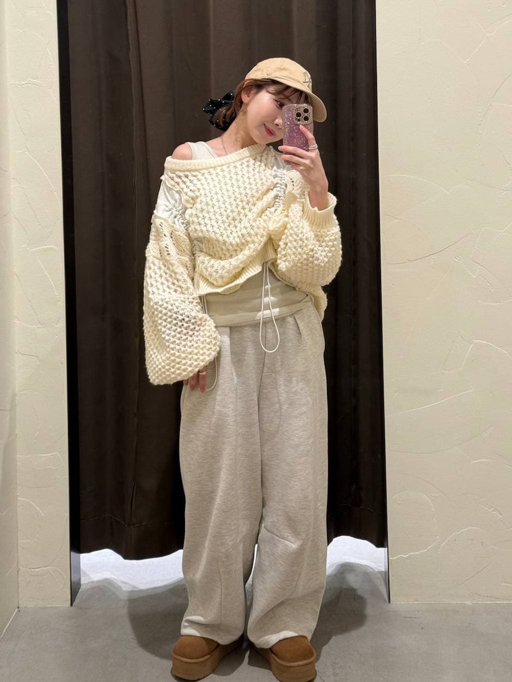 ベージュ系のタンクトップ、グレー系のスウェットパンツ、ブラック系のシュシュを着用したレディースの冬コーディネートの3枚目の写真