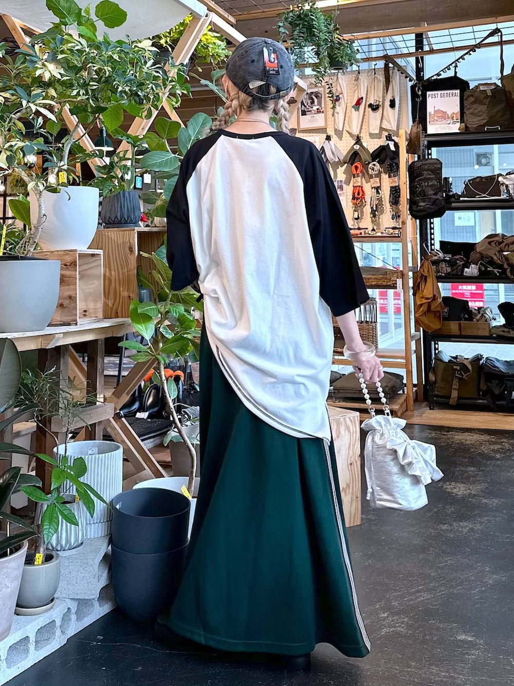 ブラック系のサンダル、グレー系のショルダーバッグ、グリーン系のスカートを着用したレディースの夏コーディネートの3枚目の写真