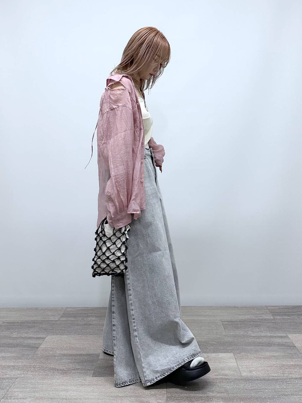 ブラック系のショルダーバッグ、ブラック系のサンダル、グレー系のデニムパンツを着用したレディースの春コーディネートの3枚目の写真