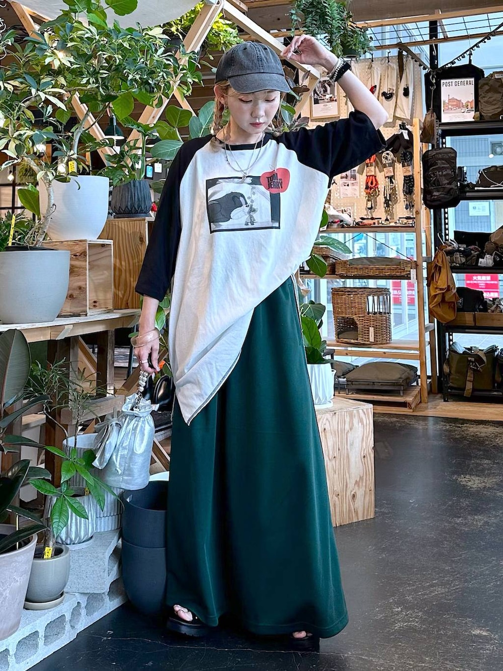 ブラック系のサンダル、グレー系のショルダーバッグ、グリーン系のスカートを着用したレディースの夏コーディネートの2枚目の写真