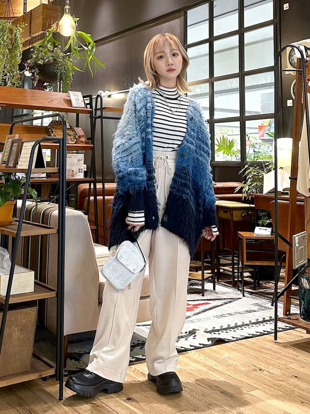 ホワイト系のニット/セーター、ベージュ系のその他パンツ、ブラック系のブーツを着用したレディースの冬コーディネートの4枚目の写真