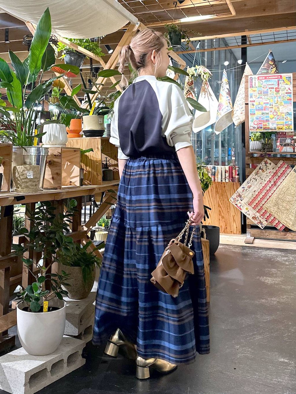 グレー系のその他パンツ、ゴールド系のブーツ、ブラウン系のショルダーバッグを着用したレディースの夏コーディネートの3枚目の写真