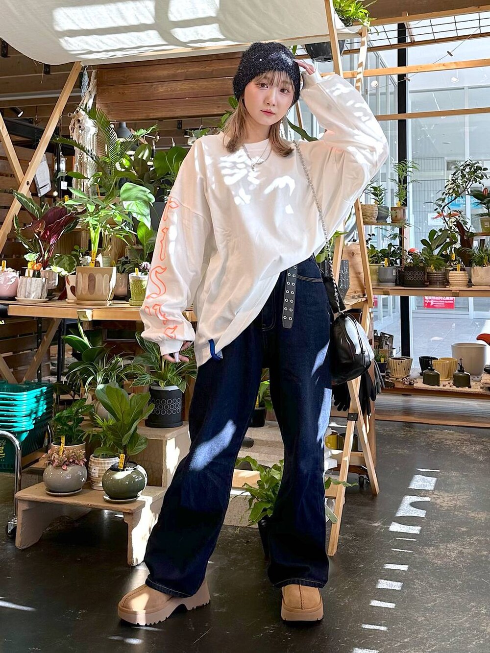 イエロー系のその他シューズ、ブルー系のデニムパンツ、ブラック系のショルダーバッグを着用したレディースの秋コーディネートの4枚目の写真
