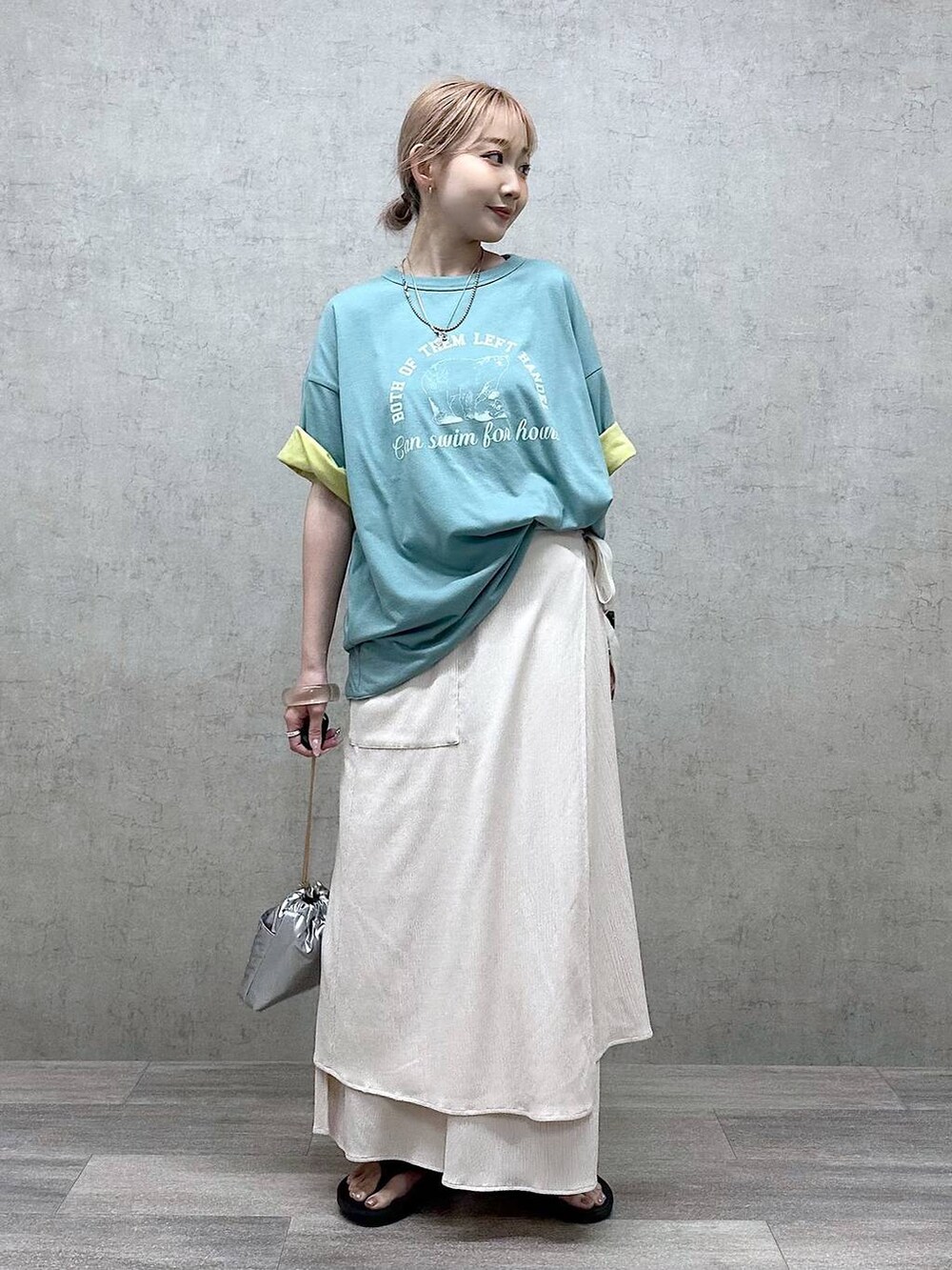 シルバー系のショルダーバッグ、グリーン系のTシャツ/カットソー、ブラック系のサンダルを着用したレディースの春コーディネートの4枚目の写真