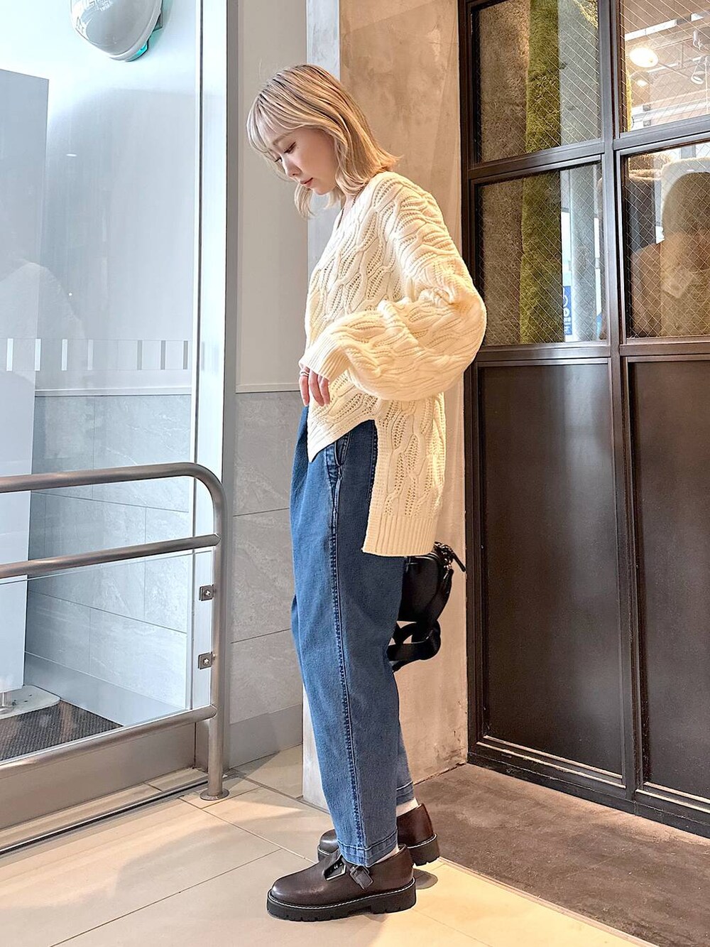 ブルー系のその他パンツ、ブラウン系のその他シューズ、ブラック系のショルダーバッグを着用したレディースの秋コーディネートの2枚目の写真