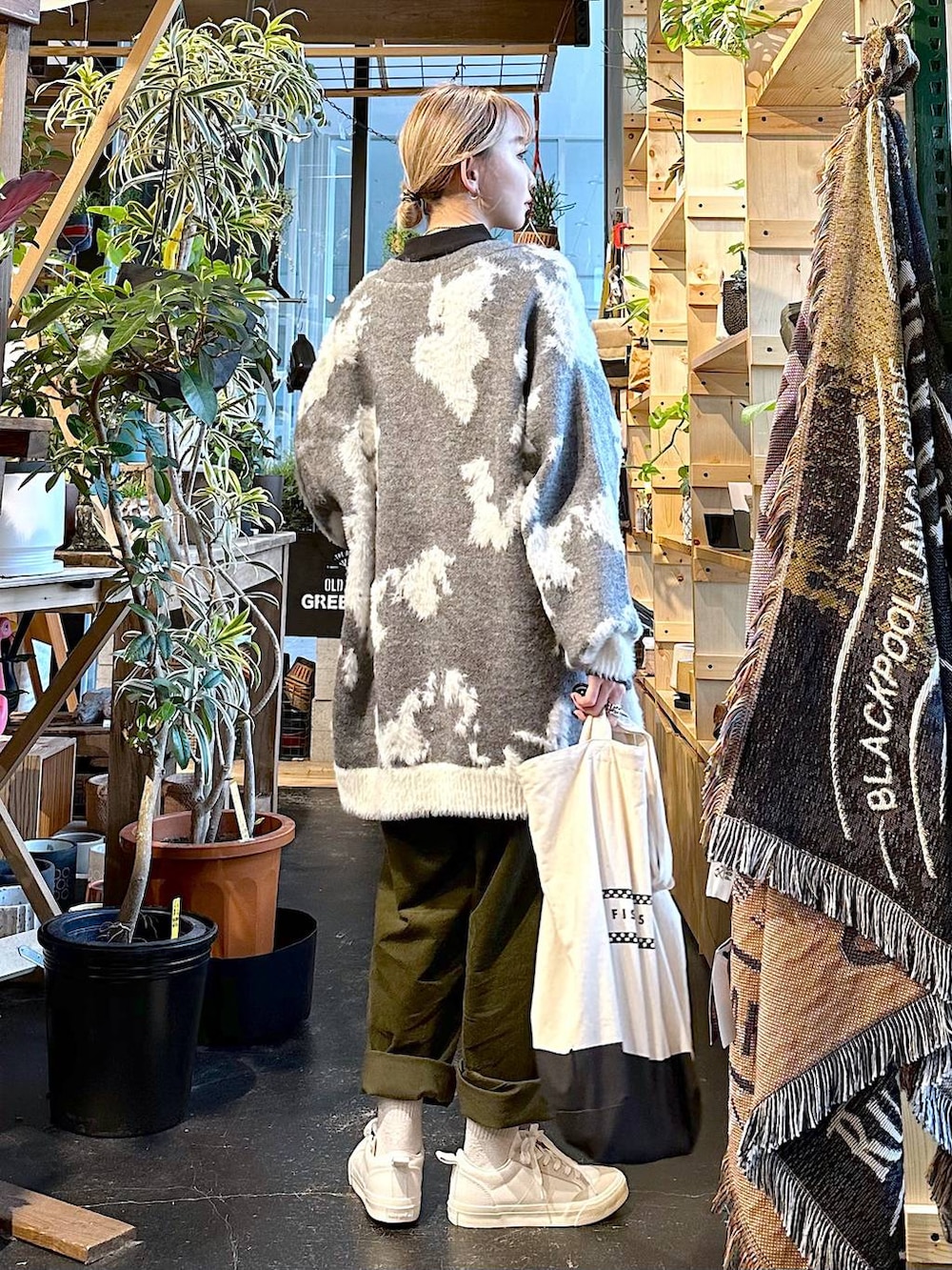 ホワイト系のスニーカー、ブラック系のトートバッグ、ブラック系のTシャツ/カットソーを着用したレディースの冬コーディネートの4枚目の写真