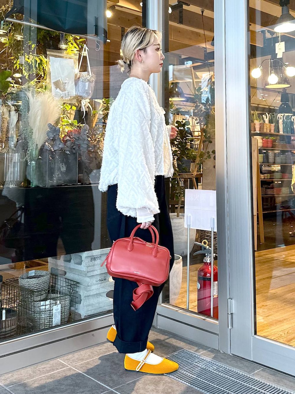 イエロー系のパンプス、ブルー系のその他パンツ、ブラウン系のショルダーバッグを着用したレディースの秋コーディネートの2枚目の写真