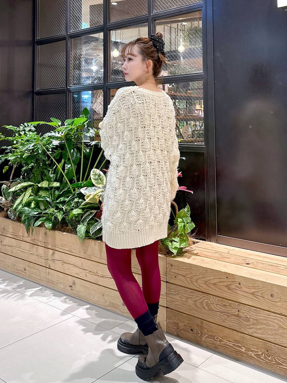 ブラウン系のショルダーバッグ、ブラウン系のブルゾン、ベージュ系のニット/セーターを着用したレディースの冬コーディネートの4枚目の写真