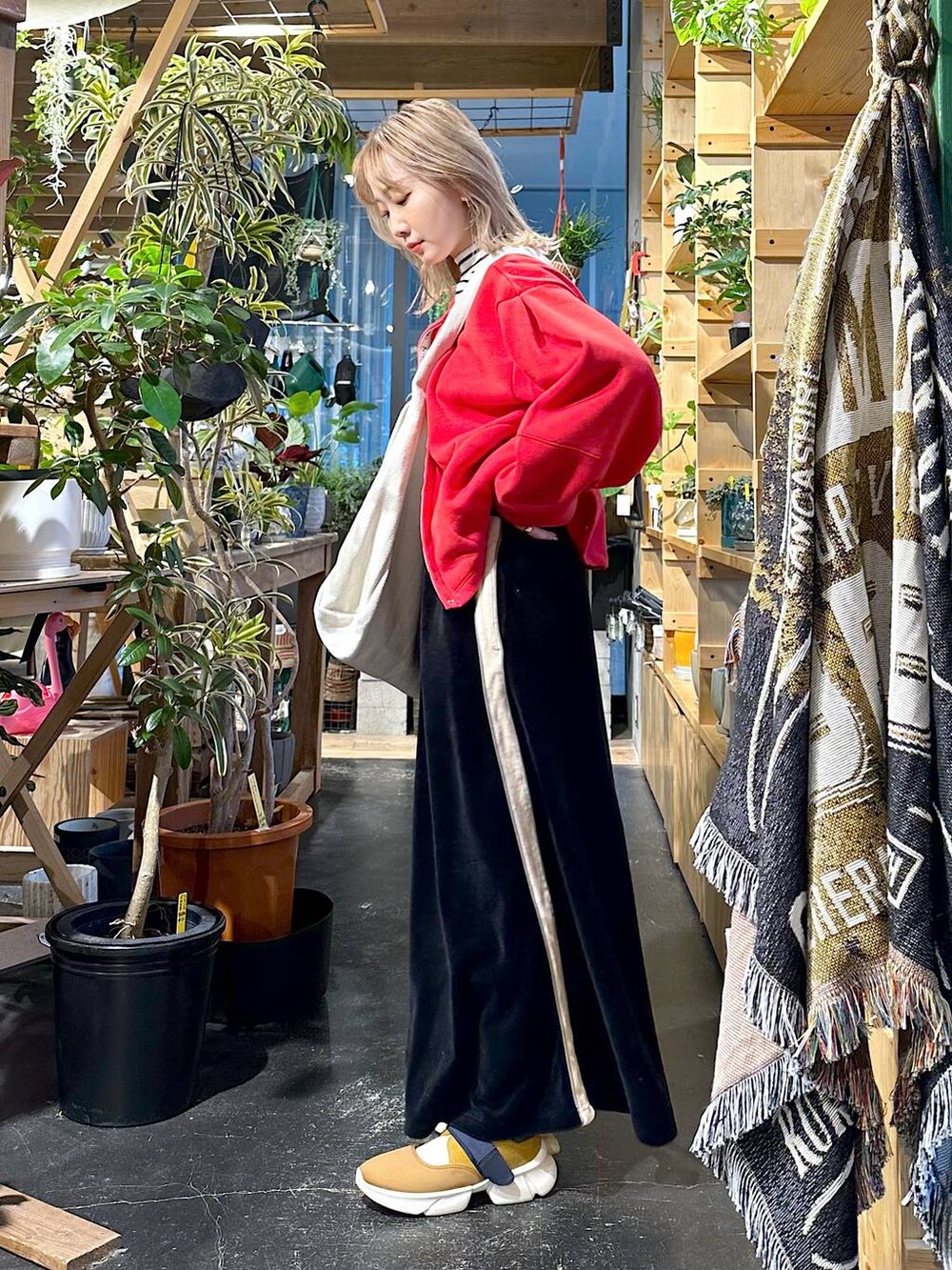 イエロー系のスニーカー、ホワイト系のTシャツ/カットソー、レッド系のTシャツ/カットソーを着用したレディースの冬コーディネートの3枚目の写真