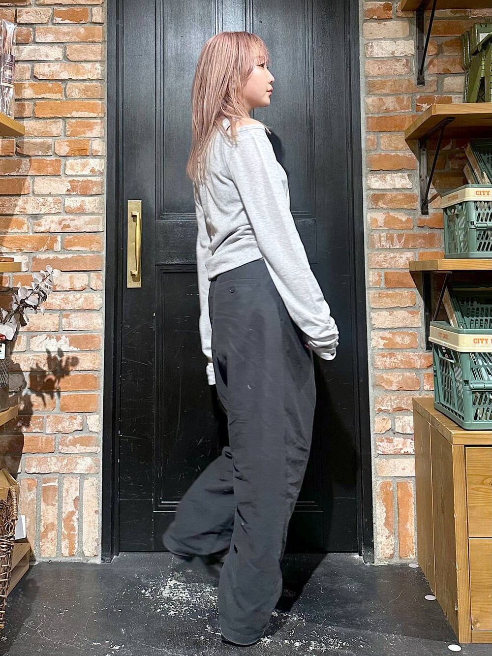 グレー系のその他パンツ、ブラウン系のブーツ、イエロー系のピアス(両耳用)を着用したレディースの冬コーディネートの2枚目の写真