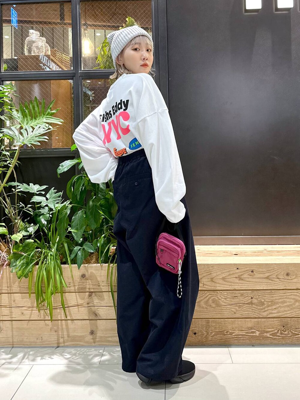 パープル系のショルダーバッグ、ブルー系のチノパンツ、ブラック系のスニーカーを着用したレディースの秋コーディネートの4枚目の写真