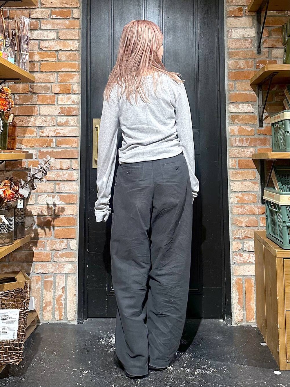 グレー系のその他パンツ、ブラウン系のブーツ、イエロー系のピアス(両耳用)を着用したレディースの冬コーディネートの3枚目の写真