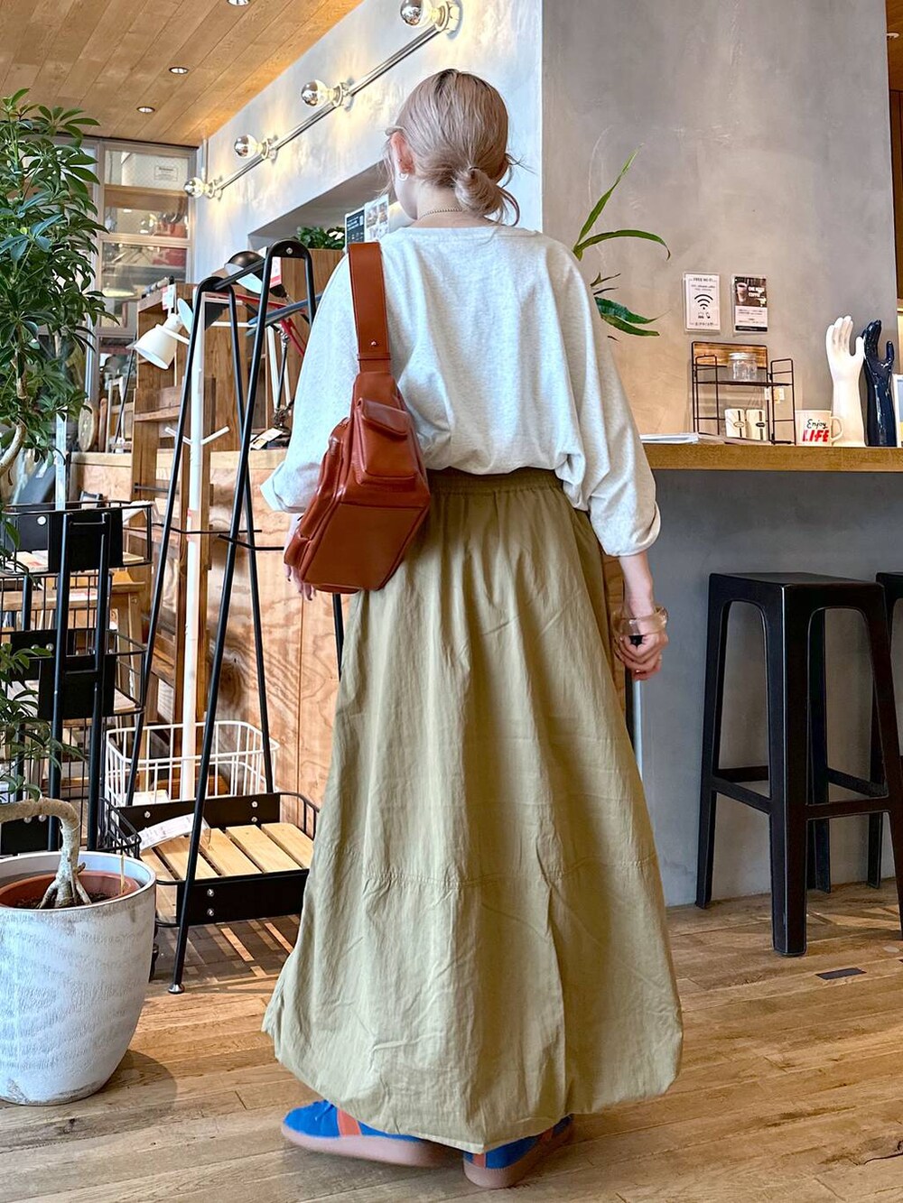 ベージュ系のTシャツ/カットソー、ブラウン系のショルダーバッグ、ブルー系のスニーカーを着用したレディースの夏コーディネートの4枚目の写真