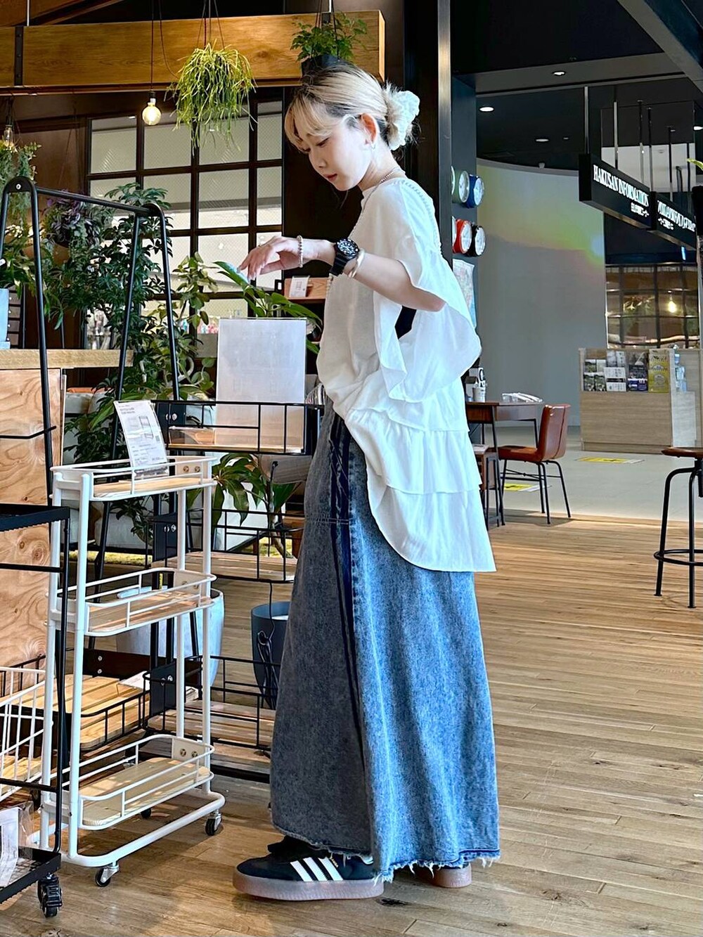 ブルー系のスカート、ブラック系のスニーカー、ホワイト系のシュシュを着用したレディースの夏コーディネートの3枚目の写真