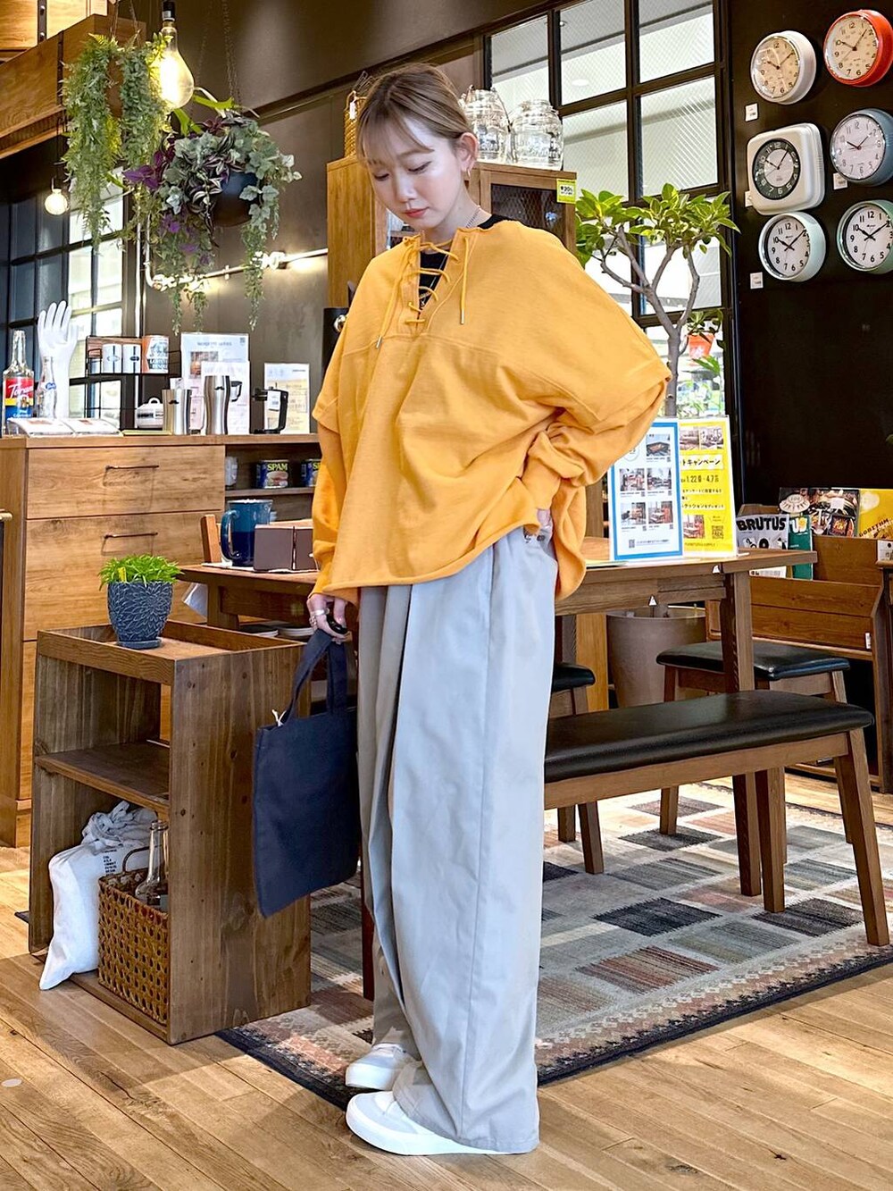 ホワイト系のスニーカー、グレー系のチノパンツ、グレー系のトートバッグを着用したレディースの冬コーディネートの2枚目の写真
