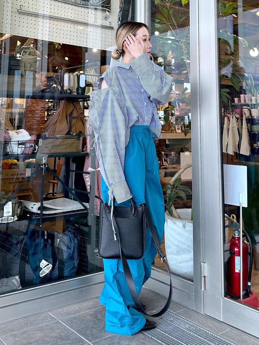 ブラック系のトートバッグ、その他のパンプス、ブルー系のシャツ/ブラウスを着用したレディースの春コーディネートの2枚目の写真