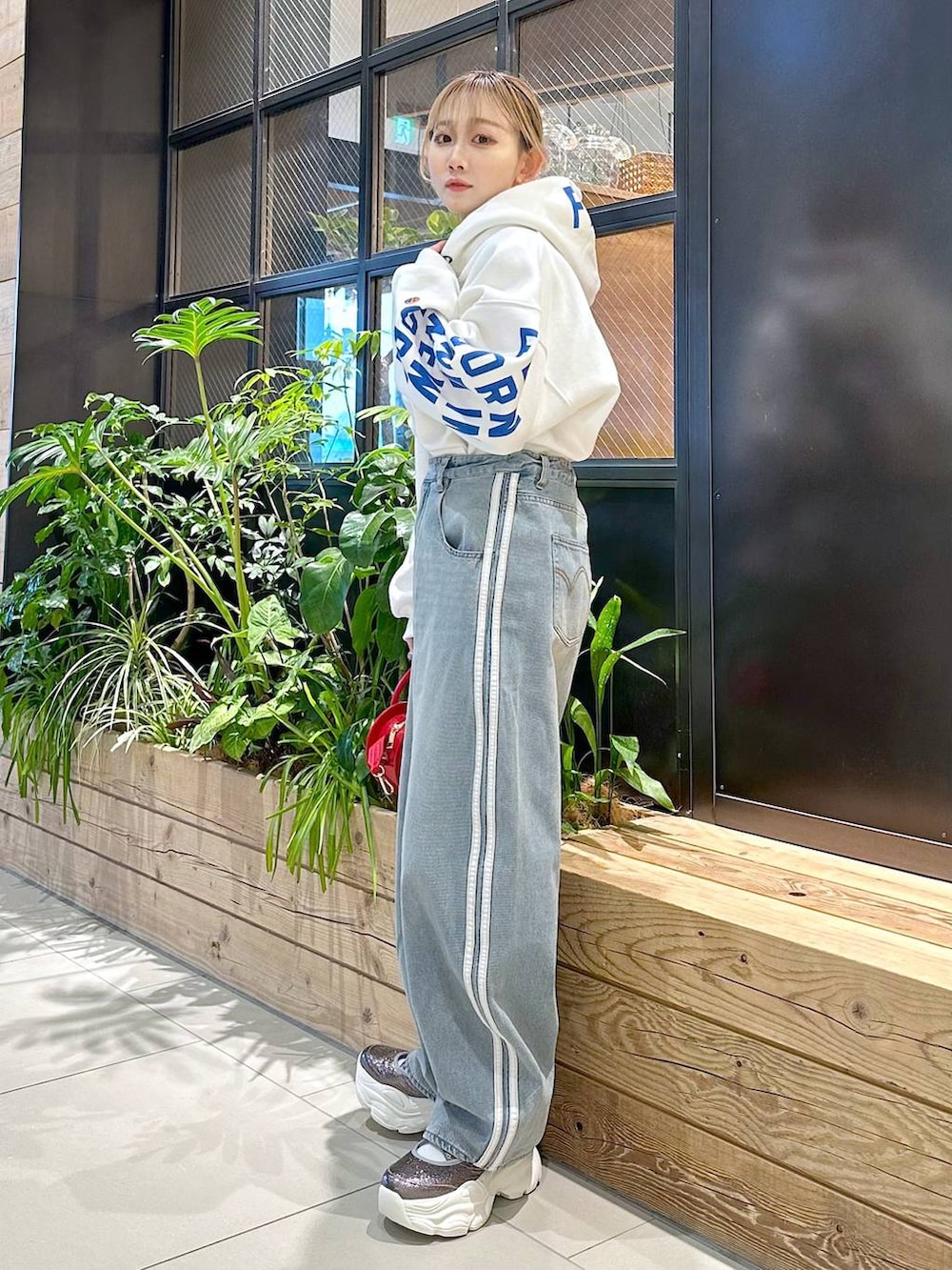 レッド系のショルダーバッグ、その他のパーカーを着用したレディースの冬コーディネートの2枚目の写真