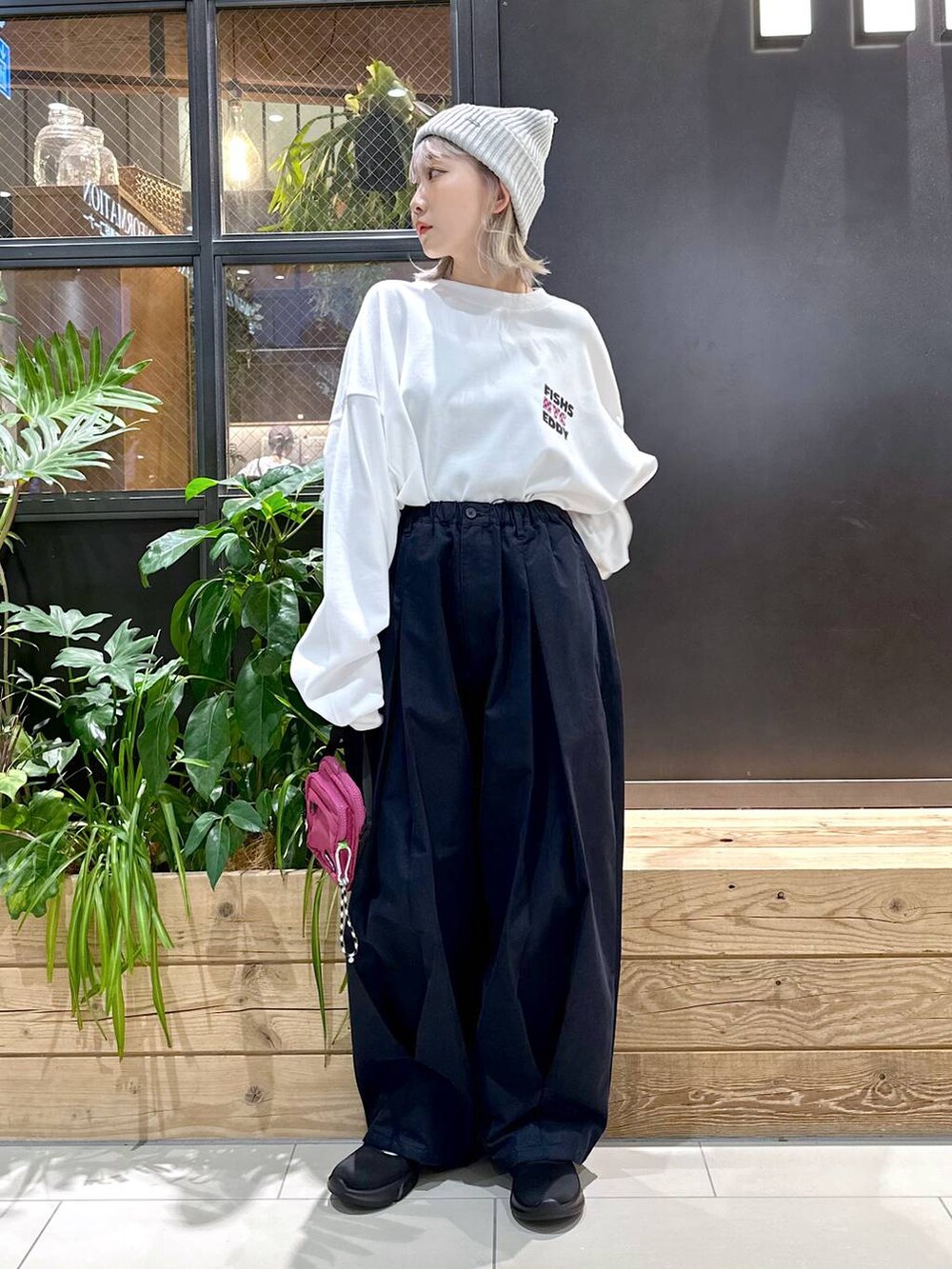 パープル系のショルダーバッグ、ブルー系のチノパンツ、ブラック系のスニーカーを着用したレディースの秋コーディネートの3枚目の写真