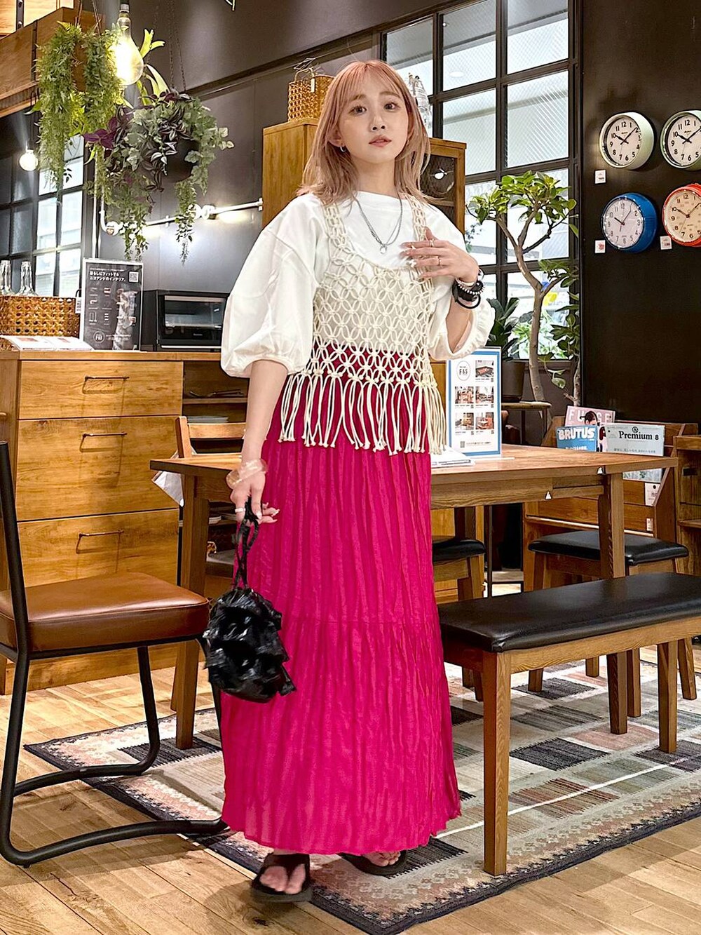 ブラック系のショルダーバッグ、ピンク系のスカート、ホワイト系のTシャツ/カットソーを着用したレディースの春コーディネートの4枚目の写真