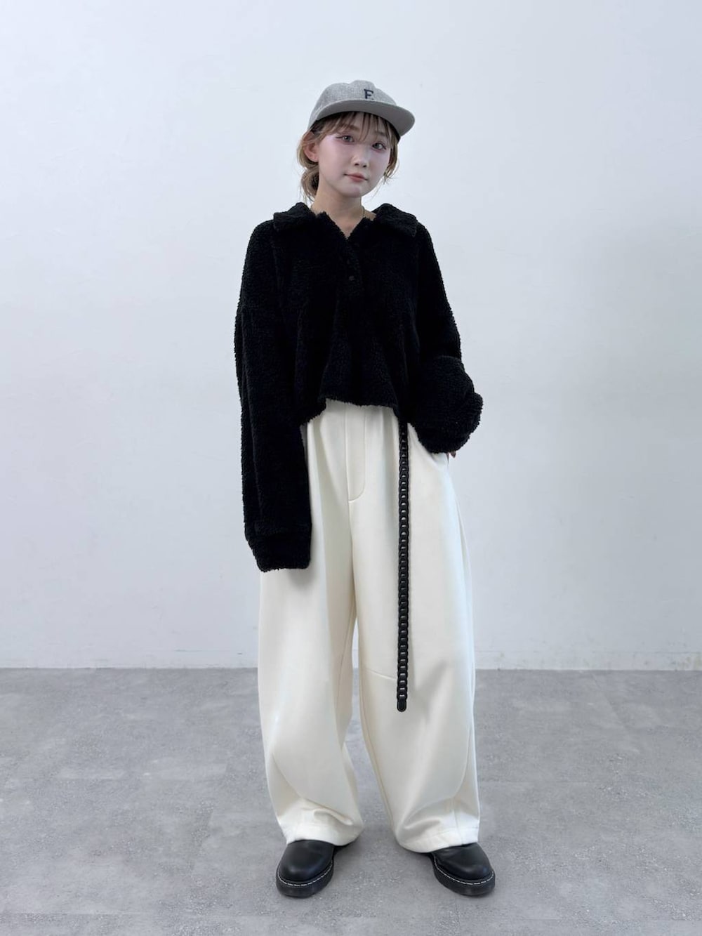 ベージュ系のその他パンツ、ブラック系のポロシャツ、グレー系のキャップを着用したレディースの秋コーディネートの3枚目の写真