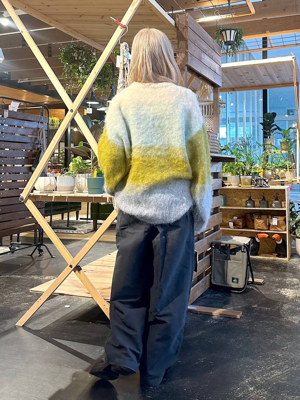 グレー系のその他パンツ、ブラウン系のブーツ、イエロー系のニット/セーターを着用したレディースの冬コーディネートの2枚目の写真